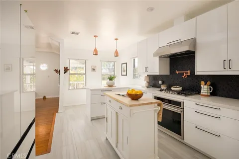 a kitchen with a sink a stove and cabinets