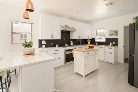a kitchen with a sink white cabinets and white appliances