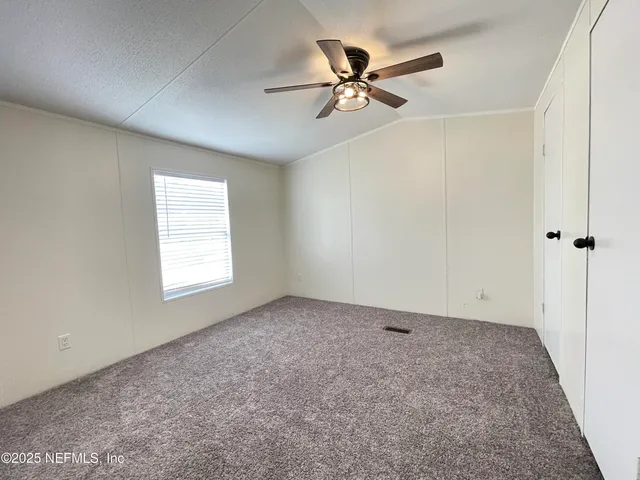 an empty room with a window and a fan
