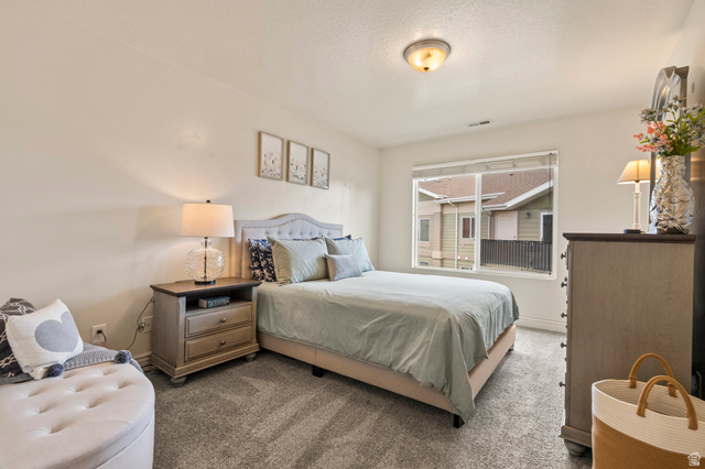 8248 South Resaca Drive, Unit J10 Sandy, UT 84070 - Photo 12 of 40 Carpeted room featuring a large window, neutral wall paint, and a built-in ceiling light fixture