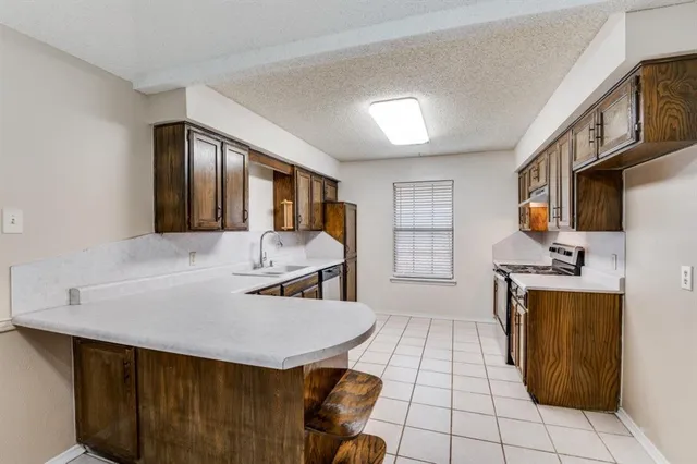 a kitchen with stainless steel appliances granite countertop a sink a stove counter space and cabinets