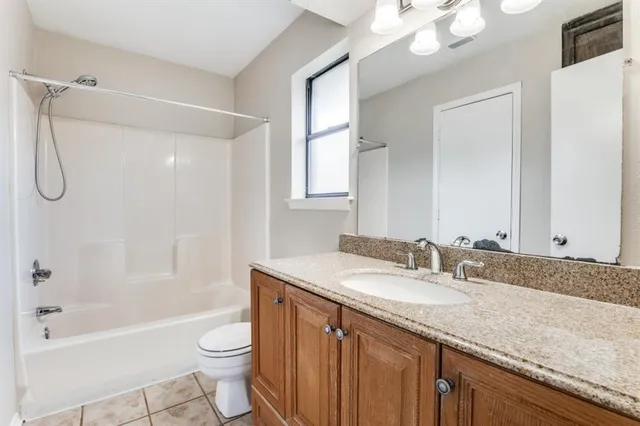a bathroom with a granite countertop sink a toilet a mirror a bathtub and shower