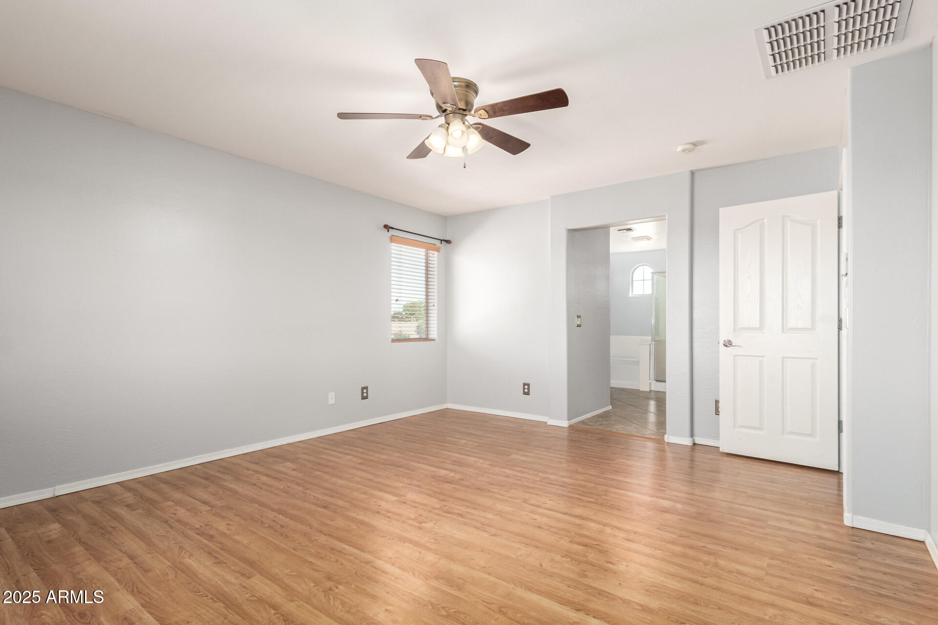6756 South Seton Avenue Gilbert, AZ 85298 - Photo 13 of 37 a view of an empty room with wooden floor and a ceiling fan
