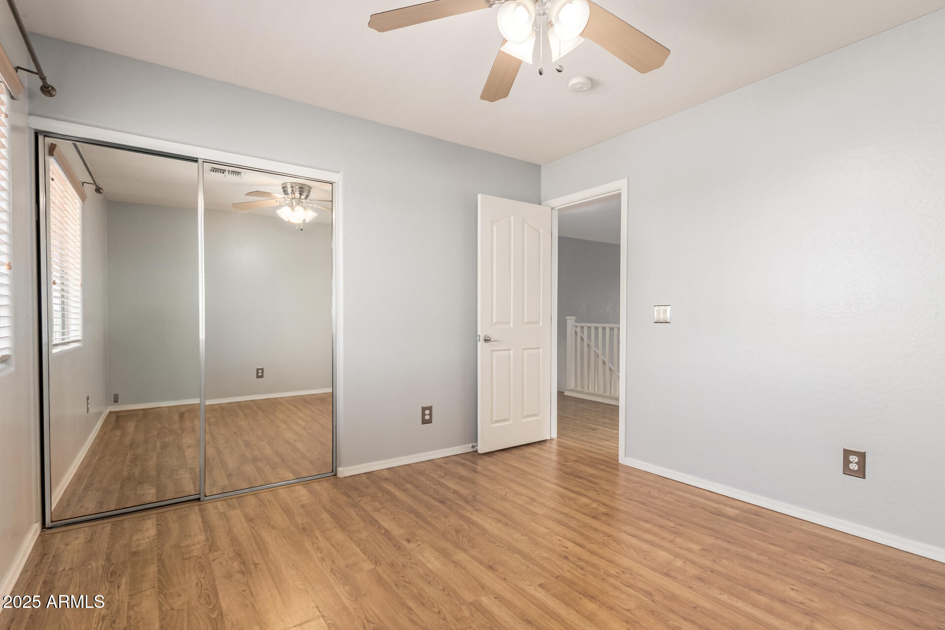 6756 South Seton Avenue Gilbert, AZ 85298 - Photo 18 of 37 an empty room with wooden floor and chandelier fan