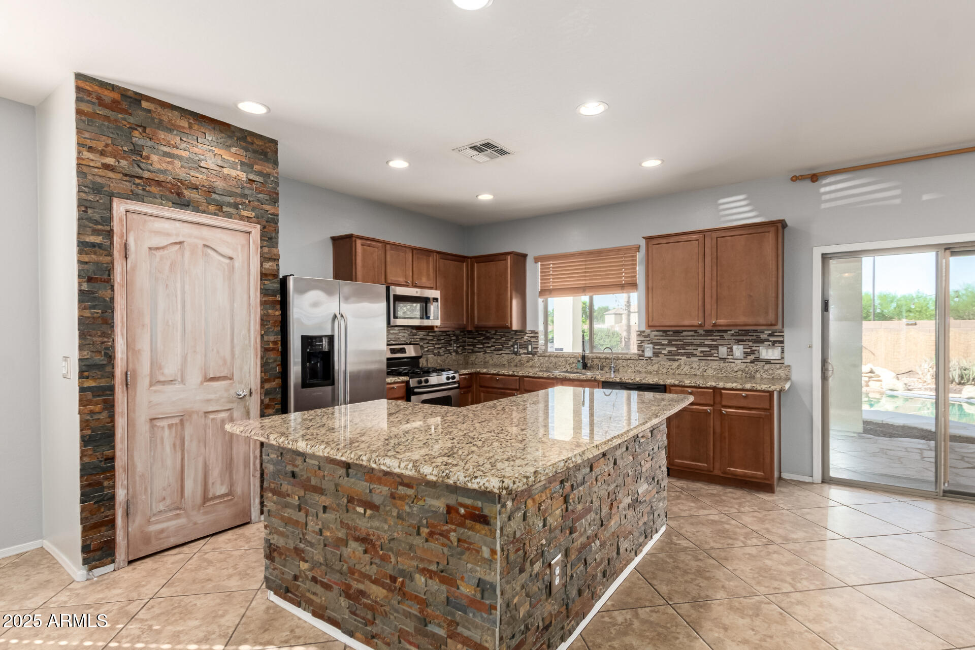 6756 South Seton Avenue Gilbert, AZ 85298 - Photo 3 of 37 a kitchen with stainless steel appliances granite countertop a stove a sink and a refrigerator