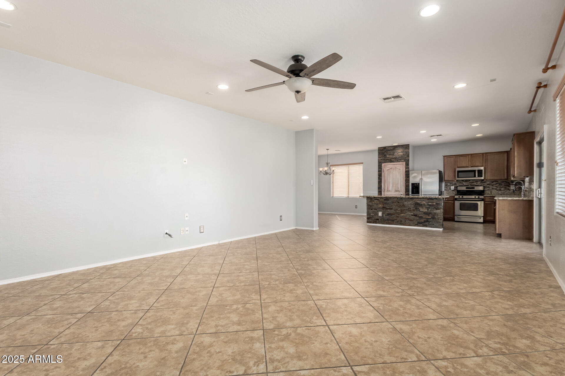 6756 South Seton Avenue Gilbert, AZ 85298 - Photo 4 of 37 a view of a kitchen with a sink and a stove top oven with wooden floor
