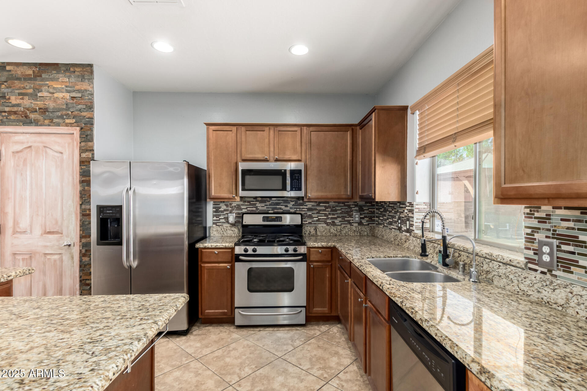 6756 South Seton Avenue Gilbert, AZ 85298 - Photo 8 of 37 a kitchen with stainless steel appliances granite countertop a sink stove refrigerator and microwave