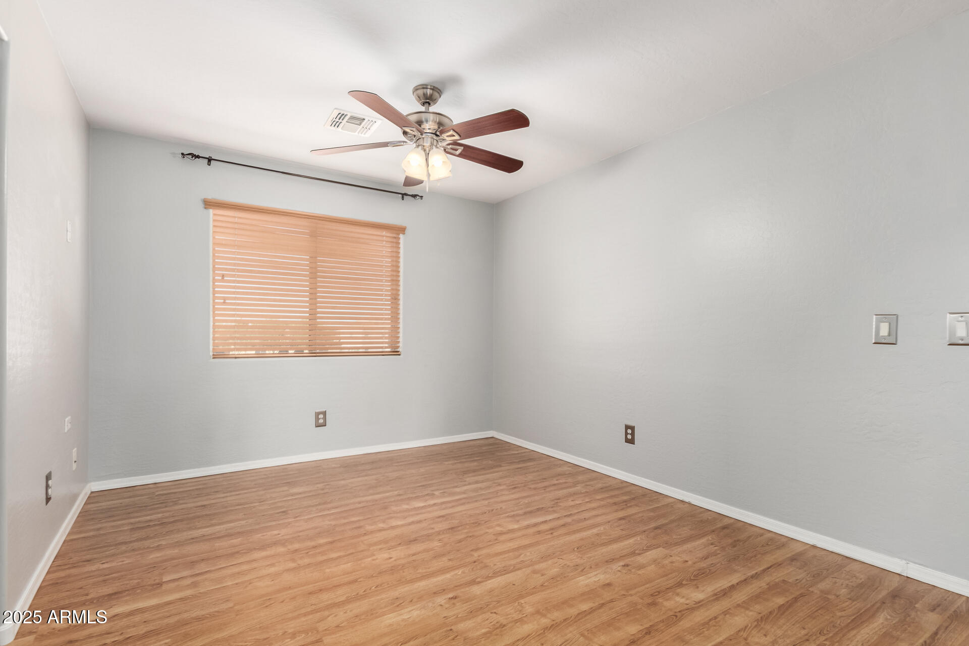6756 South Seton Avenue Gilbert, AZ 85298 - Photo 9 of 37 a view of an empty room with wooden floor and a window