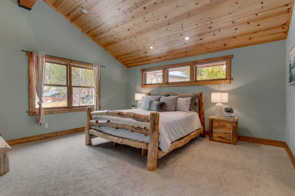 a bed sitting in a spacious bedroom next to a window