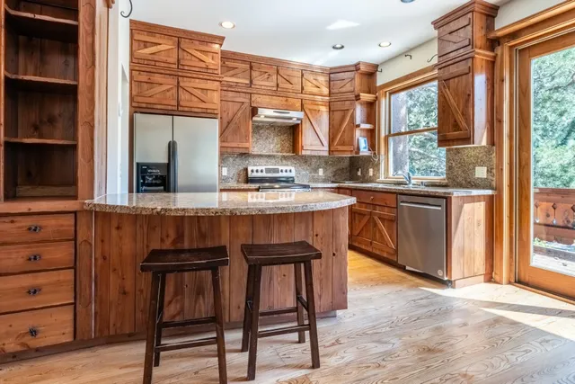 a kitchen with a sink a window and chairs