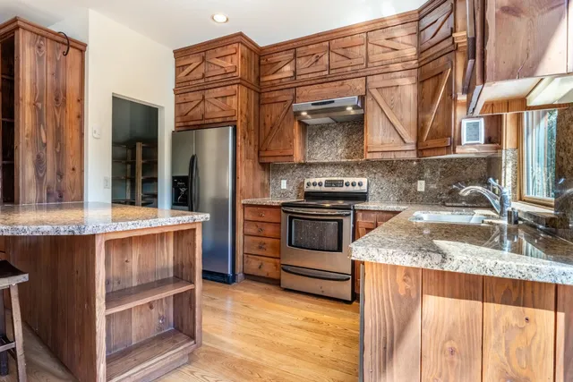 a kitchen with stainless steel appliances granite countertop a sink stove and refrigerator