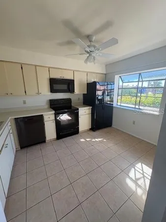 a kitchen with granite countertop a refrigerator and a stove top oven