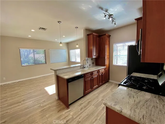 a kitchen with stainless steel appliances granite countertop a stove a sink and a refrigerator
