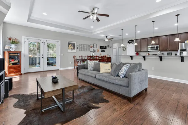 a kitchen with stainless steel appliances kitchen island granite countertop a stove a refrigerator a kitchen island a dining table and chairs with wooden floor