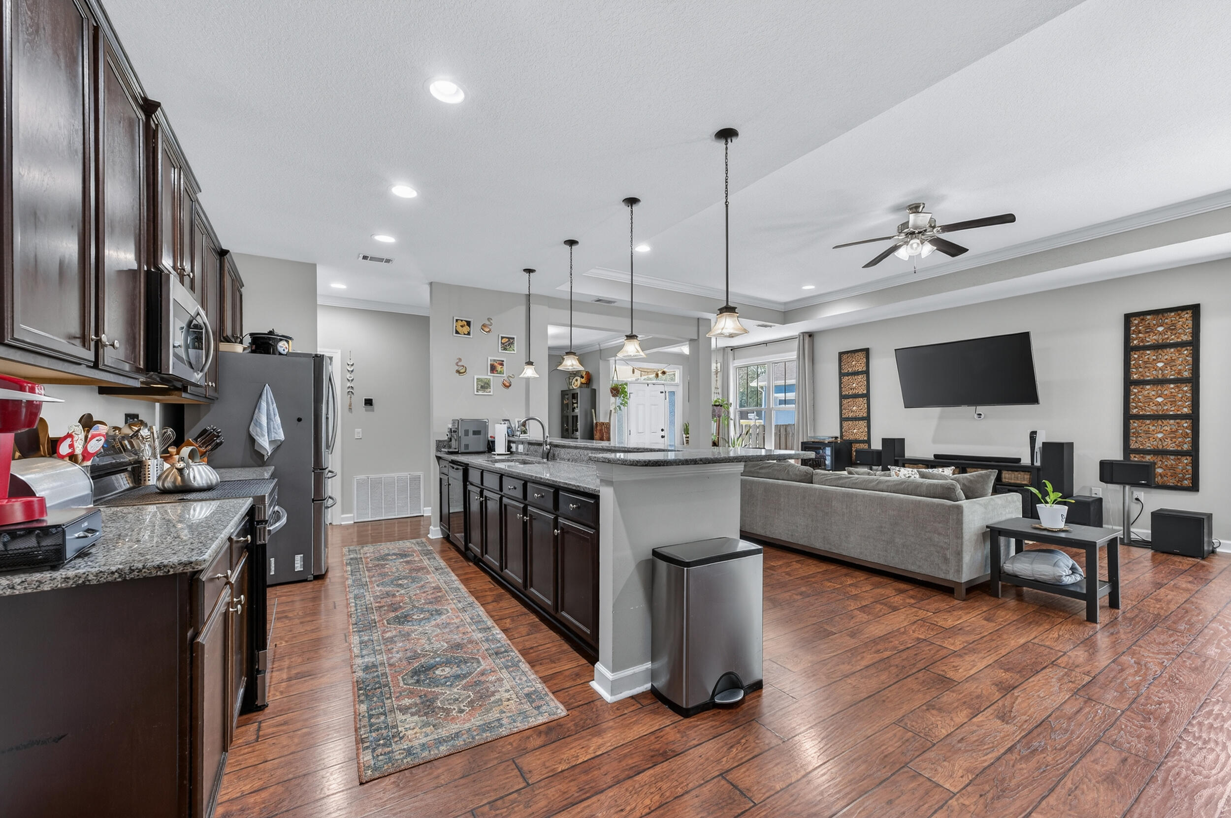 6022 Hidden Valley Road Crestview, FL 32539 - Photo 23 of 60 a kitchen with stainless steel appliances granite countertop wooden floors wooden cabinets a sink and a center island