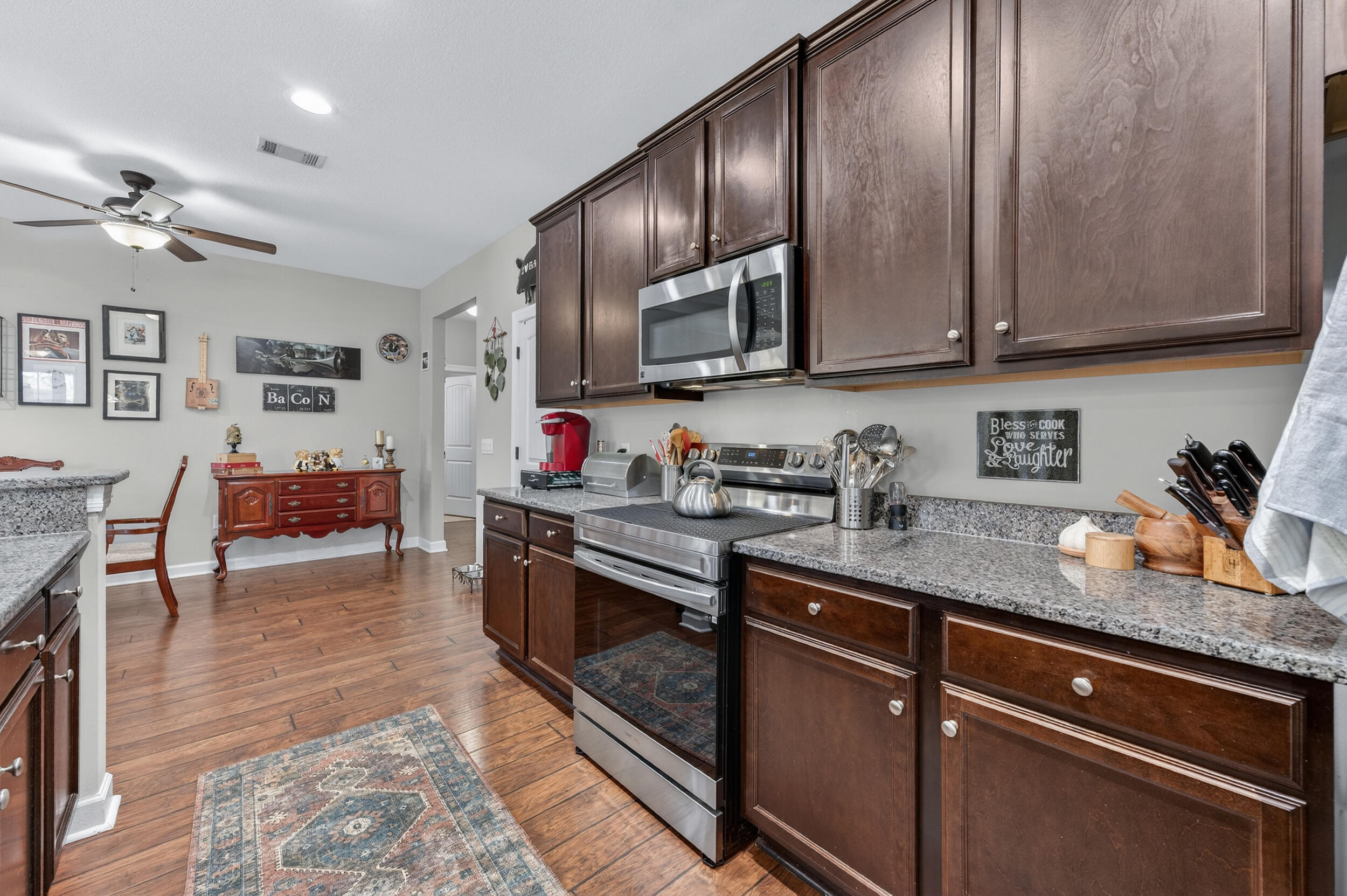 6022 Hidden Valley Road Crestview, FL 32539 - Photo 28 of 60 a kitchen with stainless steel appliances granite countertop a sink dishwasher stove top oven and cabinets with wooden floor