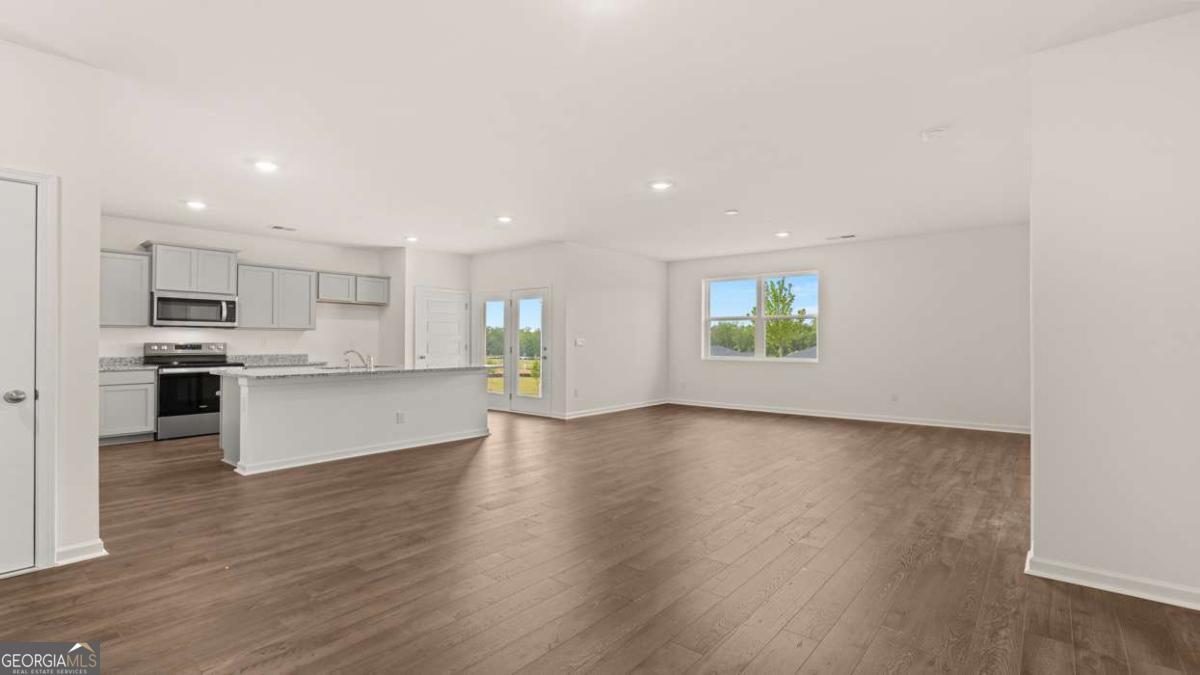 8576 Seabiscuit Road Lithonia, GA 30058 - Photo 3 of 22 a view of kitchen with wooden floor and electronic appliances