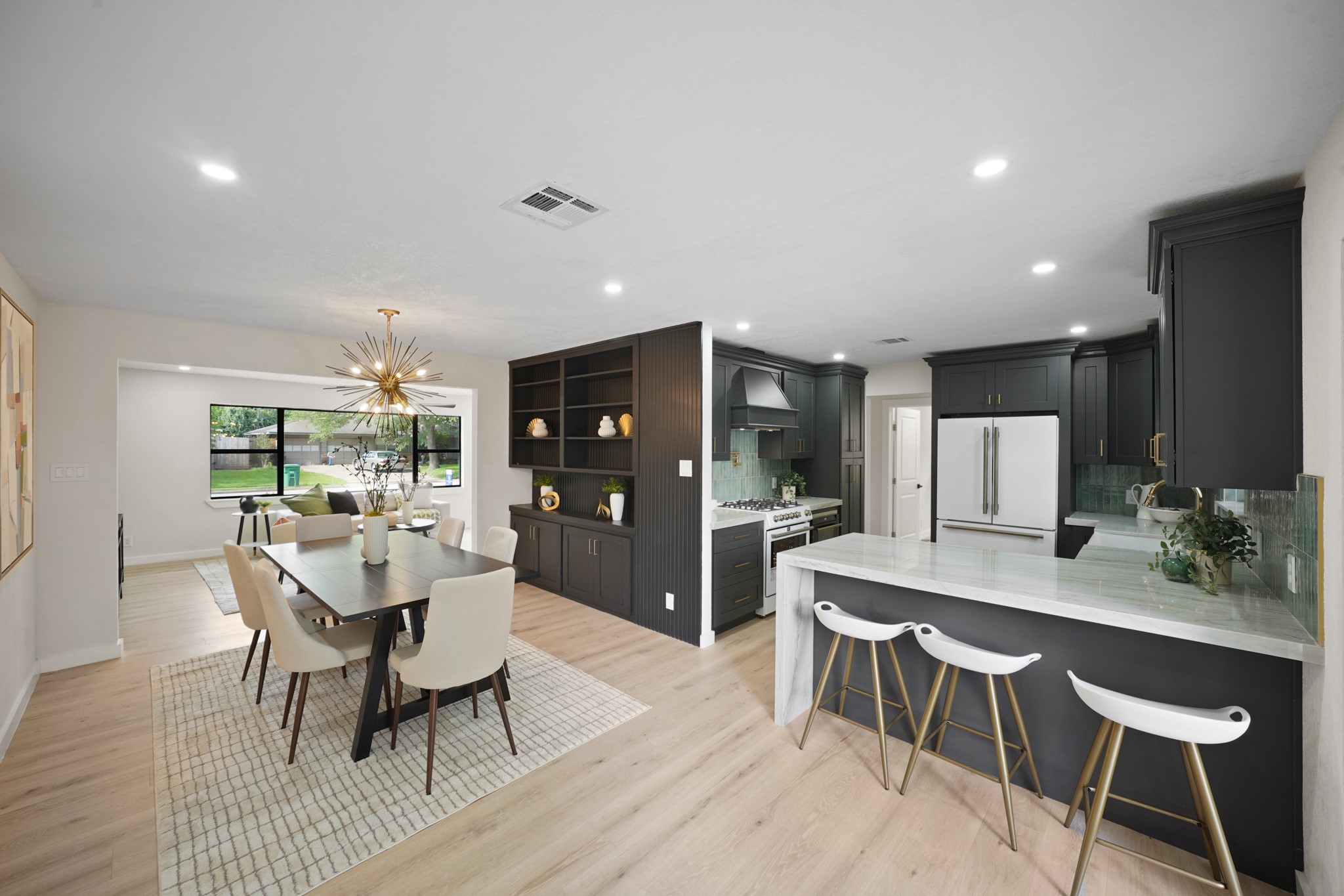 4813 Hummingbird Street Houston, TX 77035 - Photo 47 of 50 The Flowing Floorplan of the North Wing brings Friends and Family together in a Contemporary Open Concept! The Modern Kitchen features Additional Seating at the Quartzite Topped Breakfast Bar with Waterfall Edge. The Kitchen also offers LED Flush Mounts and Wide Plank White Oak Hued Engineered Floors.
