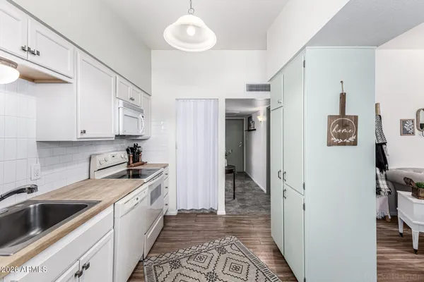 a kitchen with a refrigerator sink and cabinets