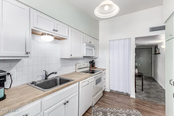 a kitchen with stainless steel appliances granite countertop a sink a stove and a refrigerator