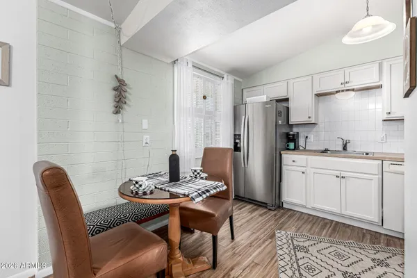 a kitchen with a refrigerator and chairs