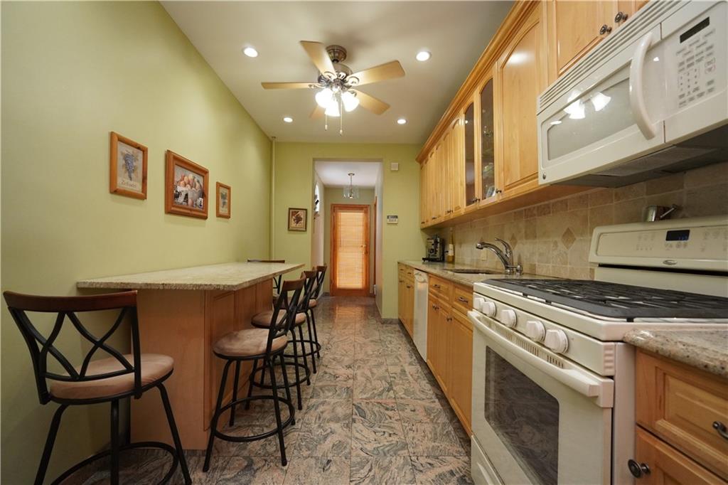 1463 84th Street Brooklyn, NY 11228 - Photo 13 of 30 a kitchen with stainless steel appliances granite countertop a stove a sink dishwasher and a refrigerator