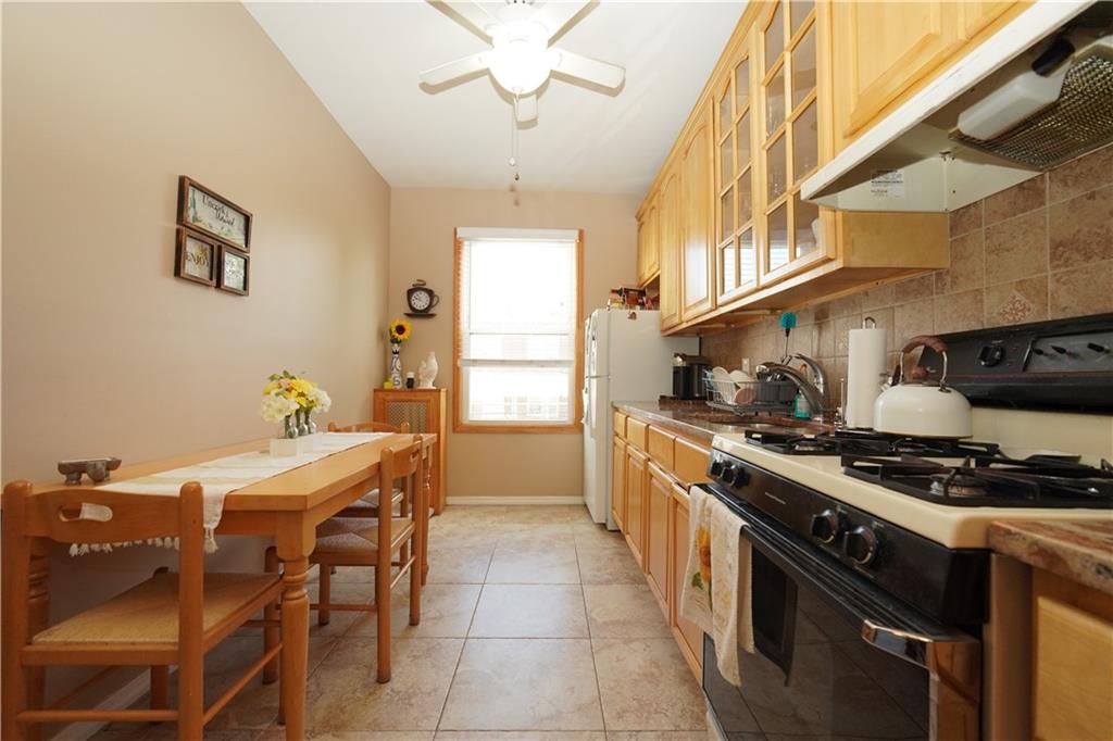 1463 84th Street Brooklyn, NY 11228 - Photo 18 of 30 a kitchen with a stove a sink and a refrigerator
