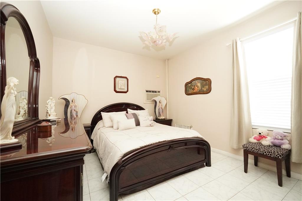 1463 84th Street Brooklyn, NY 11228 - Photo 20 of 30 a bedroom with a bed and a chandelier