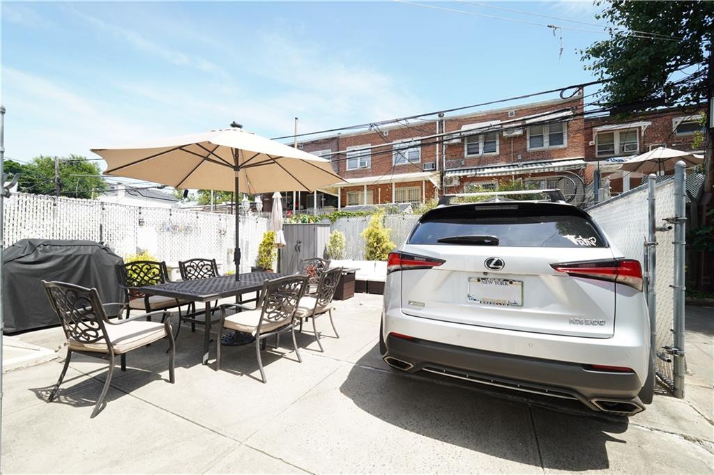 1463 84th Street Brooklyn, NY 11228 - Photo 28 of 30 a roof deck with a table and chairs under an umbrella