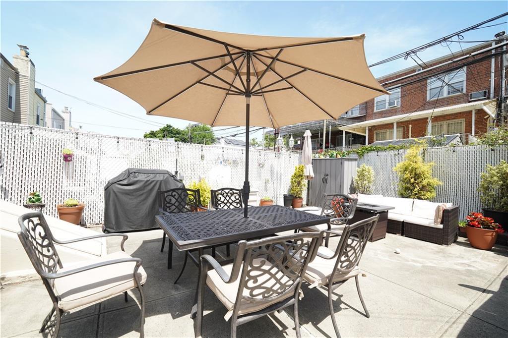 1463 84th Street Brooklyn, NY 11228 - Photo 29 of 30 a view of a patio with a table and chairs under an umbrella