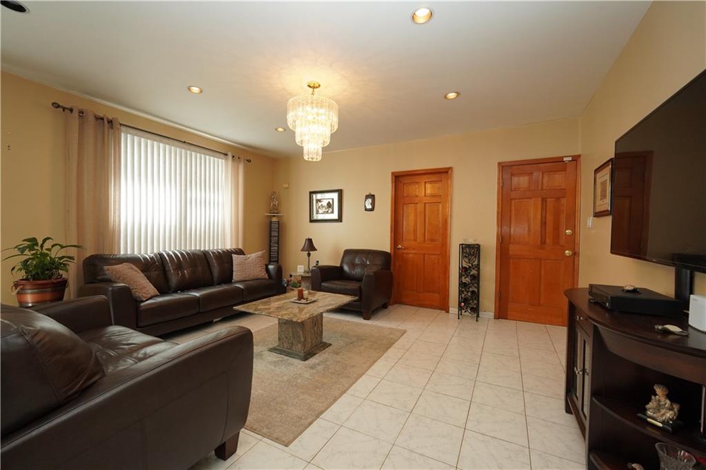 1463 84th Street Brooklyn, NY 11228 - Photo 6 of 30 a living room with furniture a large window and a flat screen tv