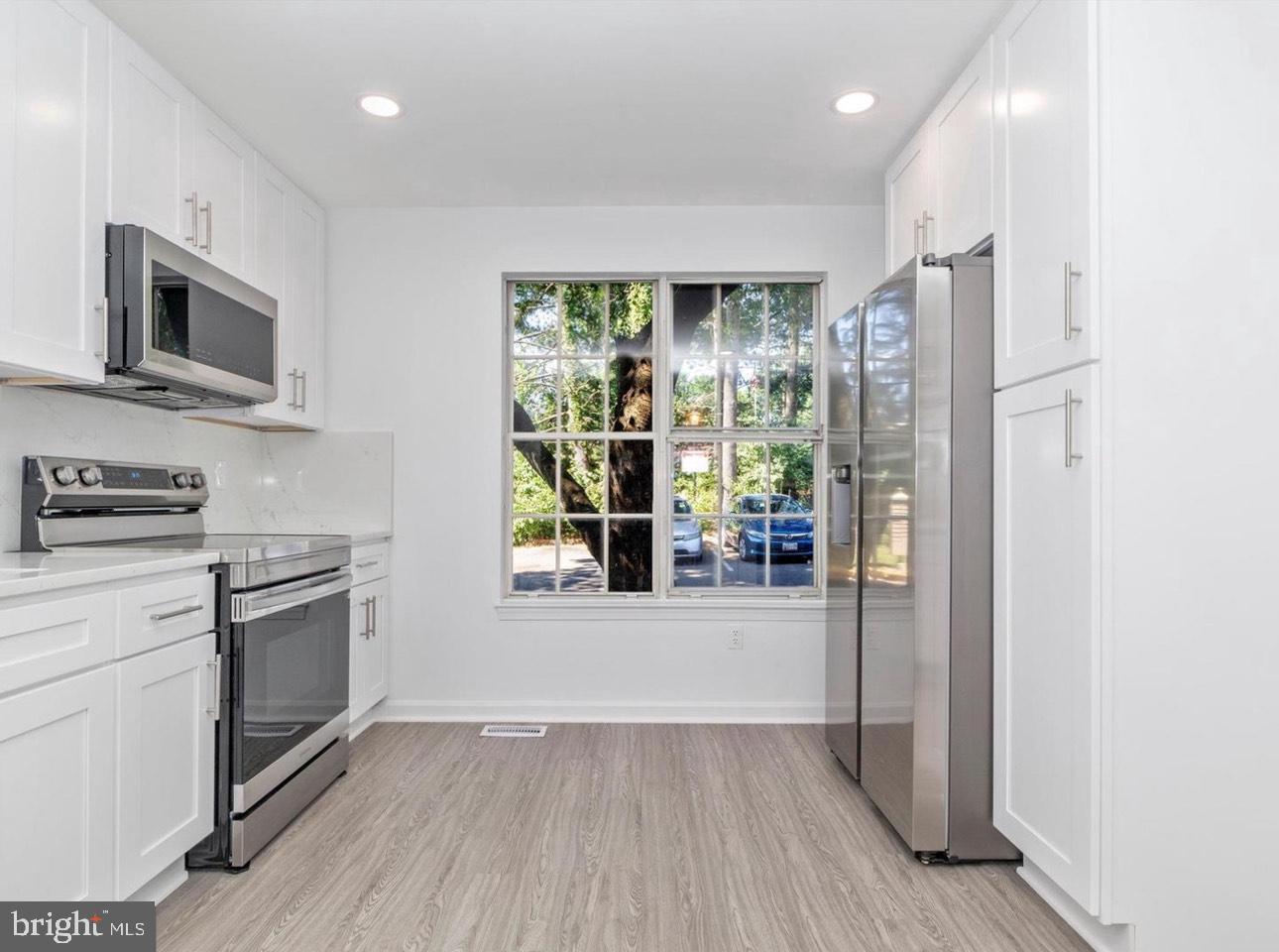 3930 Ferrara Drive Silver Spring, MD 20906 - Photo 2 of 15 a kitchen with stainless steel appliances granite countertop a refrigerator oven a sink dishwasher and a stove with wooden floor