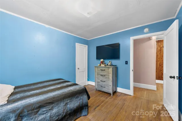 a bedroom with a bed and a flat tv screen on dresser