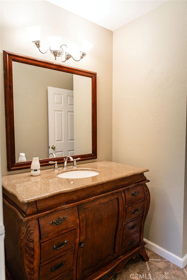 5085 Boyer Road Mariposa, CA 95338 - Photo 34 of 75 a bathroom with a granite countertop sink and a mirror