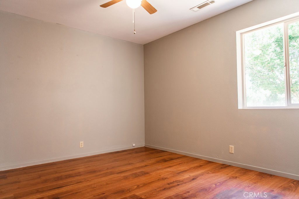 5085 Boyer Road Mariposa, CA 95338 - Photo 55 of 75 an empty room with wooden floor chandelier fan and windows