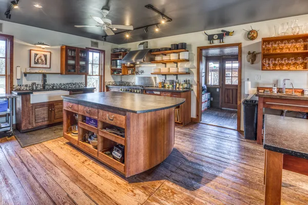 a kitchen with stainless steel appliances granite countertop a stove and a wooden floors