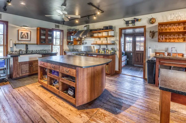 a kitchen with stainless steel appliances granite countertop a stove and a wooden floors