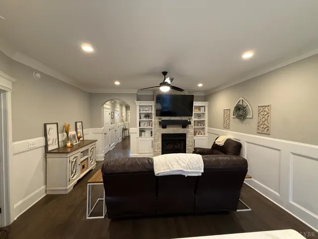 a living room with furniture kitchen view and a wooden floor