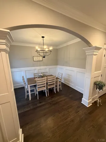 a dining room with furniture a chandelier and wooden floor