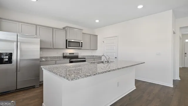 a view of a kitchen with wooden floor and electronic appliances