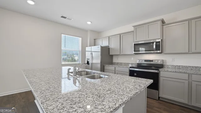 a kitchen with stainless steel appliances granite countertop a sink stove and refrigerator