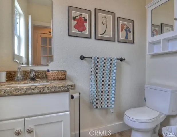 a bathroom with a granite countertop toilet and a sink