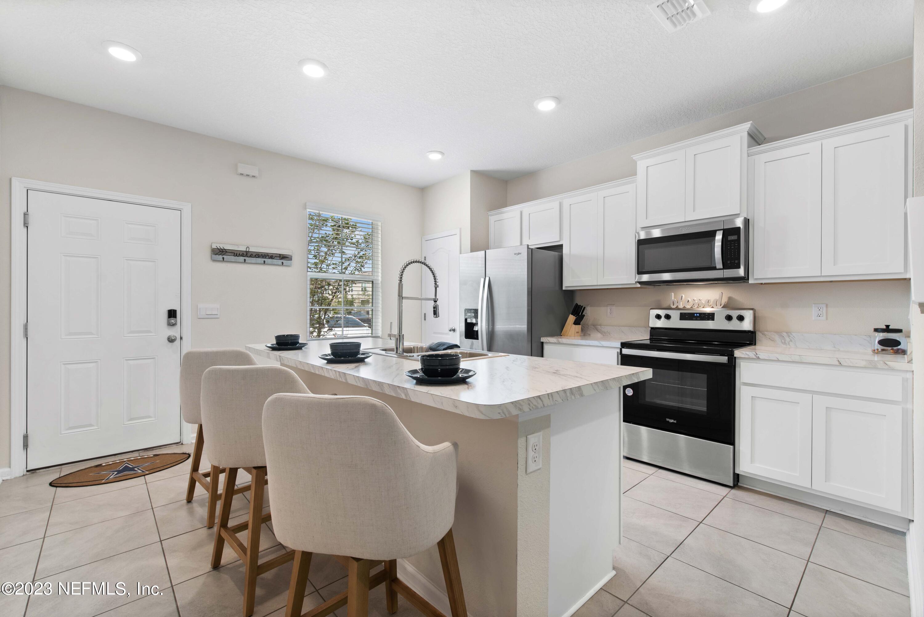 920 Rotary Road Jacksonville, FL 32211 - Photo 4 of 15 a kitchen with stainless steel appliances granite countertop a stove a sink a microwave and a refrigerator
