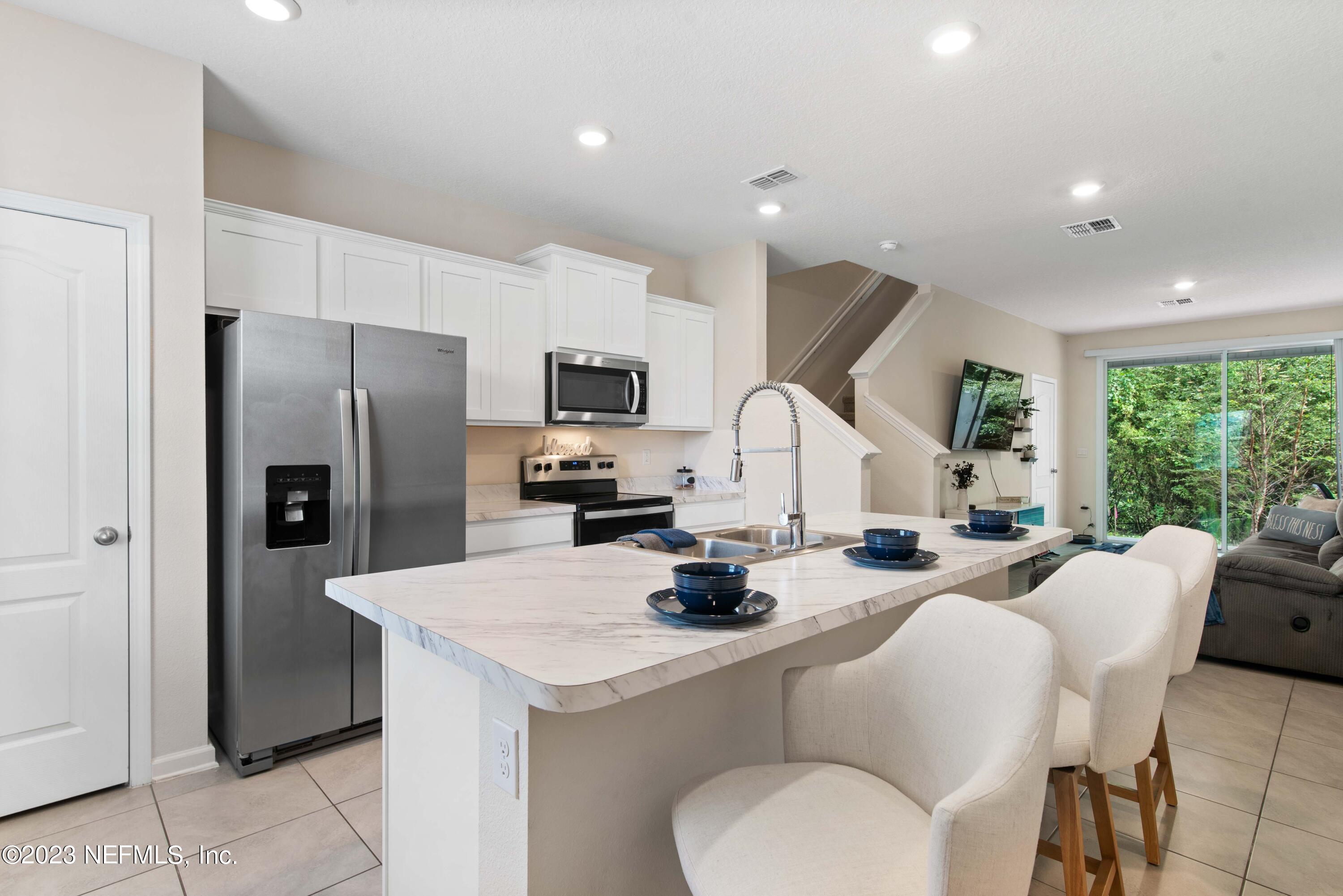 920 Rotary Road Jacksonville, FL 32211 - Photo 5 of 15 a kitchen with sink a refrigerator and chairs