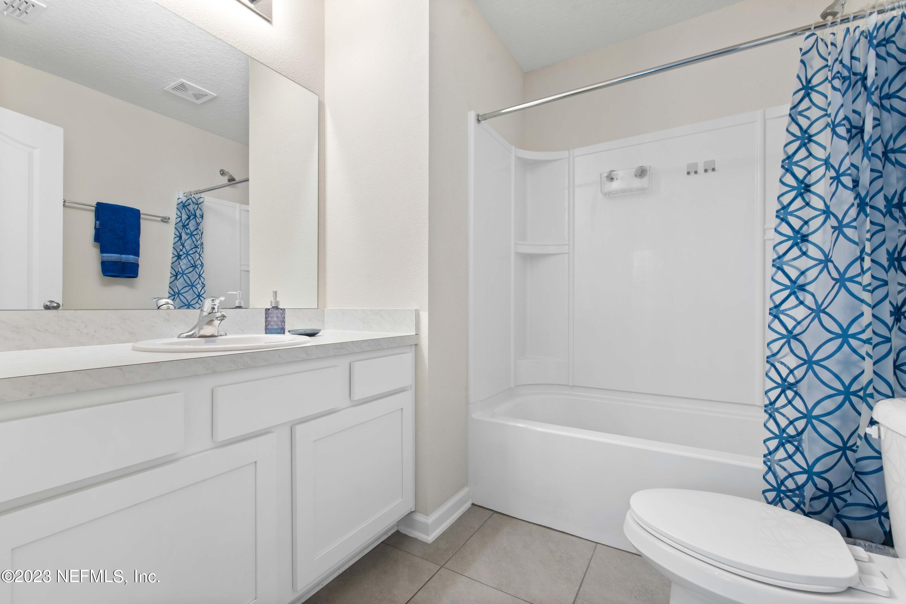 920 Rotary Road Jacksonville, FL 32211 - Photo 9 of 15 a bathroom with a bathtub toilet sink vanity and mirror