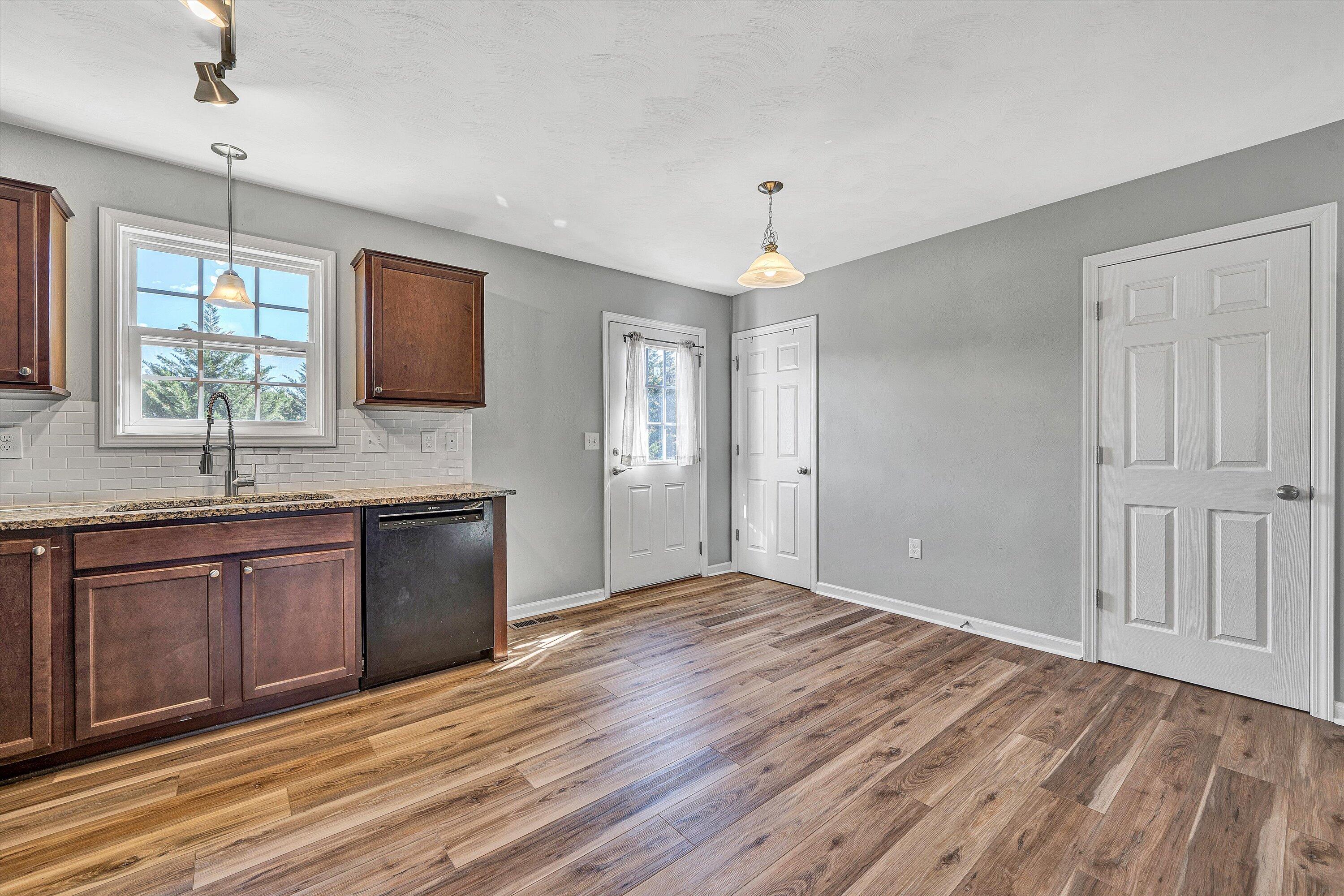 555 Old Fort Road Rocky Mount, VA 24151 - Photo 12 of 35 a kitchen with granite countertop a sink window and wooden floor