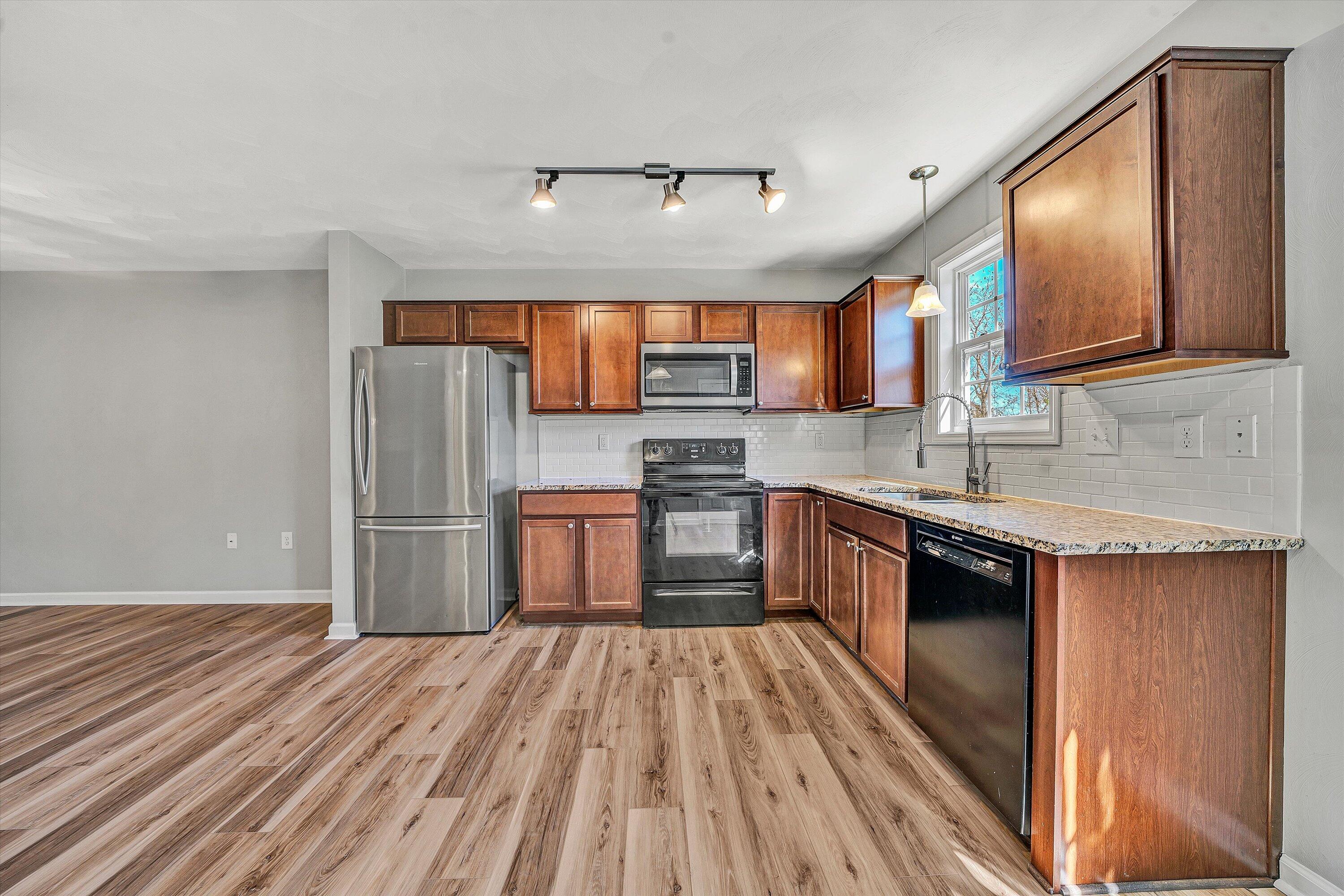 555 Old Fort Road Rocky Mount, VA 24151 - Photo 8 of 35 a kitchen with stainless steel appliances granite countertop a refrigerator a sink dishwasher a stove with wooden cabinets and floor