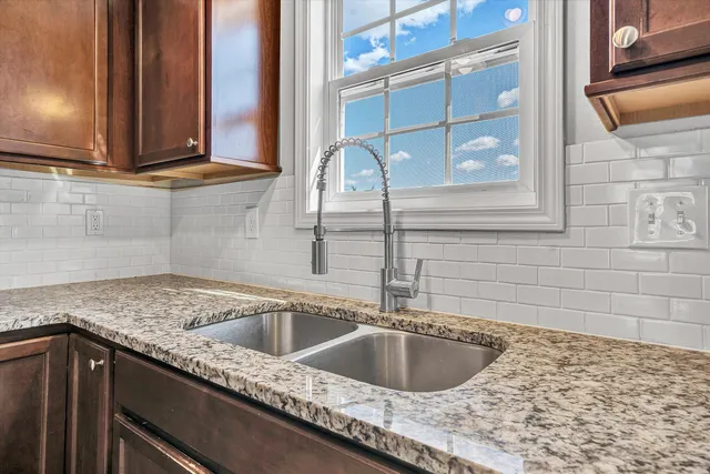 a large kitchen with stainless steel appliances granite countertop a refrigerator a stove a sink dishwasher and a oven with wooden floor