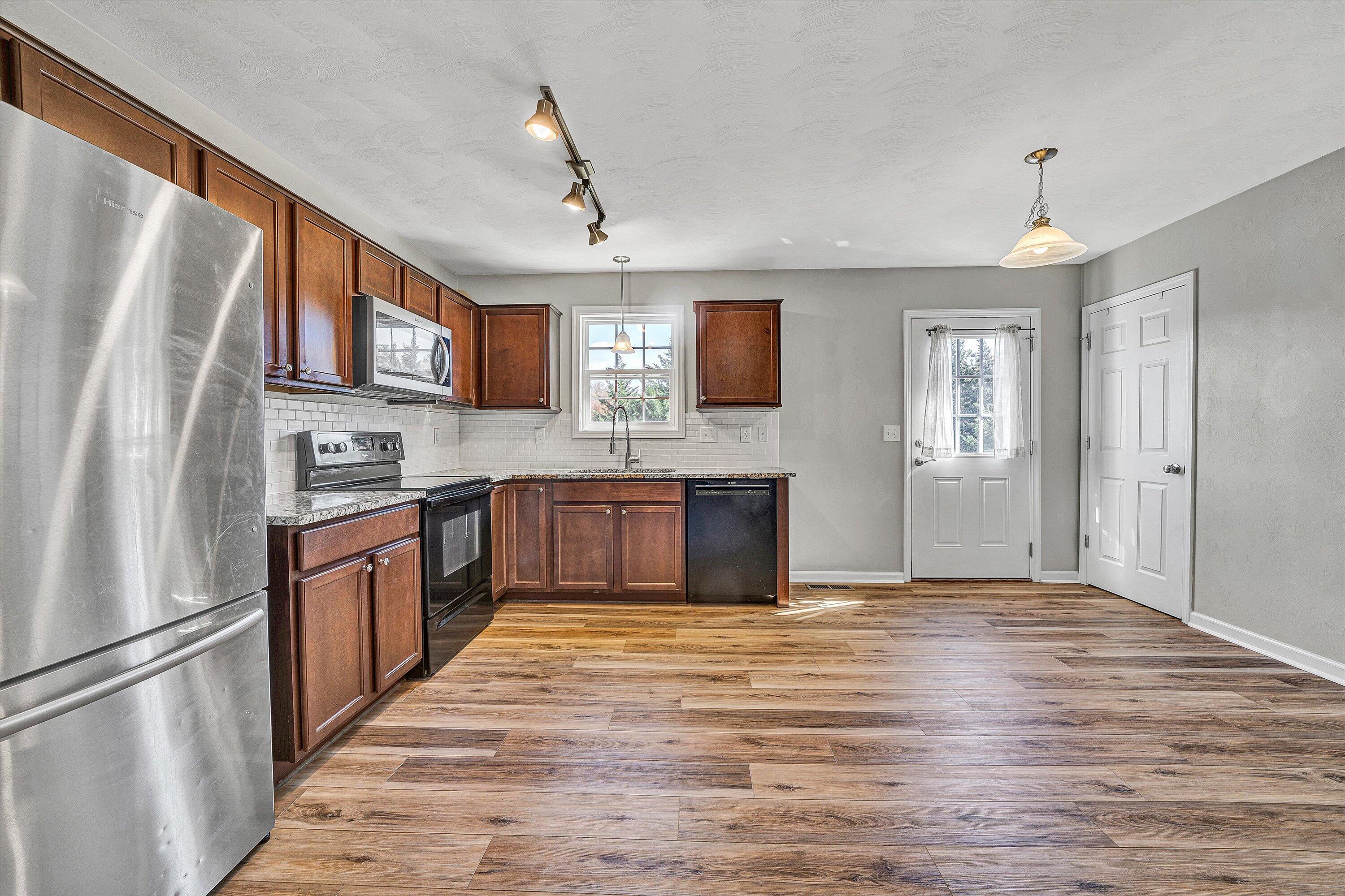 555 Old Fort Road Rocky Mount, VA 24151 - Photo 10 of 35 a large kitchen with stainless steel appliances granite countertop a refrigerator a stove a sink dishwasher and a oven with wooden floor