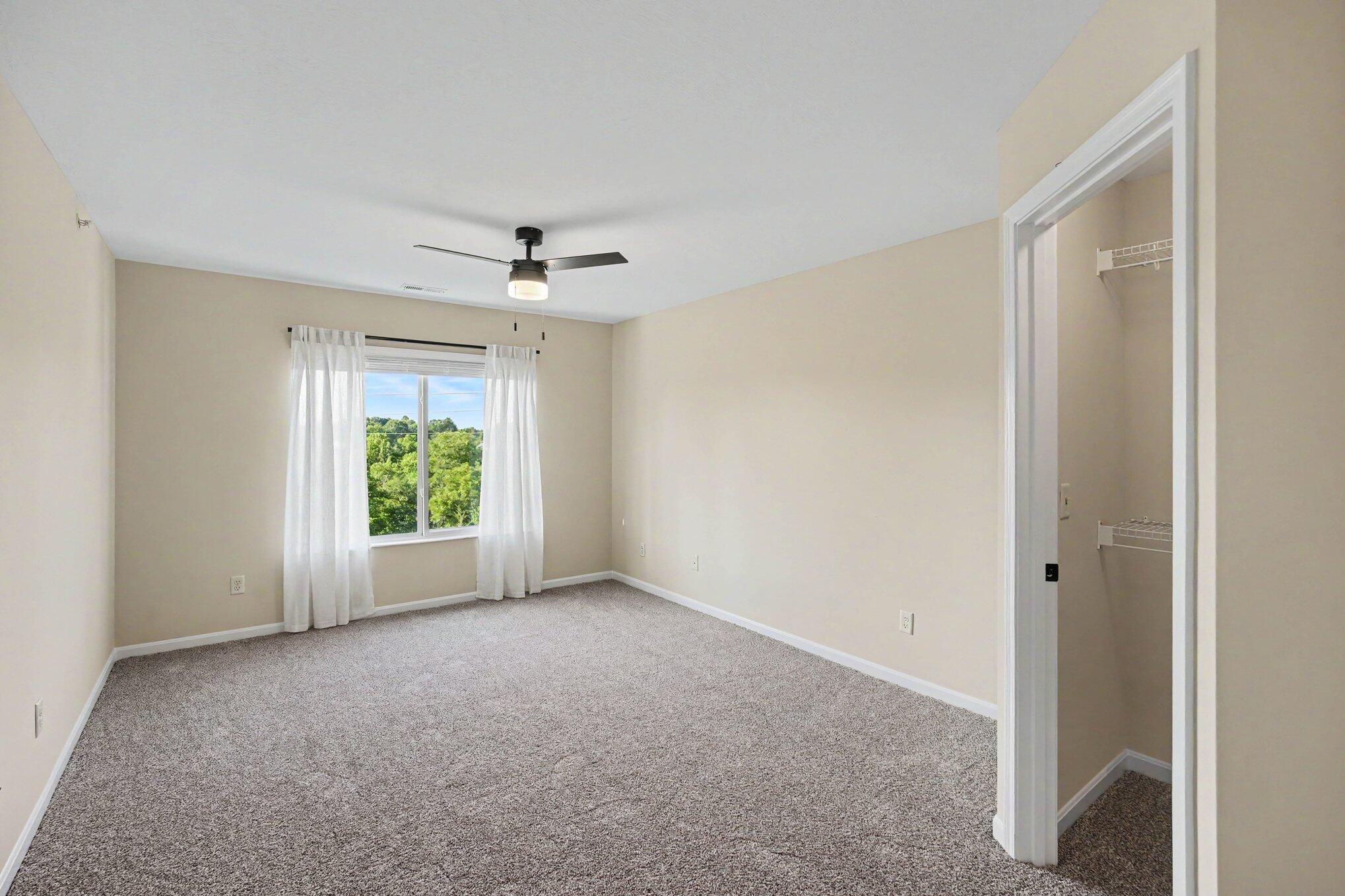 6069 Boulder View Cold Spring, KY 41076 - Photo 14 of 23 Carpeted room featuring a large window, a ceiling fan with integrated lighting, and a closet with wire shelving